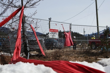 Red dresses and cloth to honour Missing and Murdered Indigenous Women and Girls, placed by members of the Tiny House Warriors, line the perimeter of a camp that houses 550 Trans Mountain Pipeline workers in Blue River, B.C., Canada, on April 14, 2022. A 2020 report by CanadaÕs National Inquiry into Missing and Murdered Indigenous Women and Girls found Òsubstantial evidenceÓ that temporary worker camps increase violence against women in nearby communities. (Photo by Aaron Hemens for HuffPost)